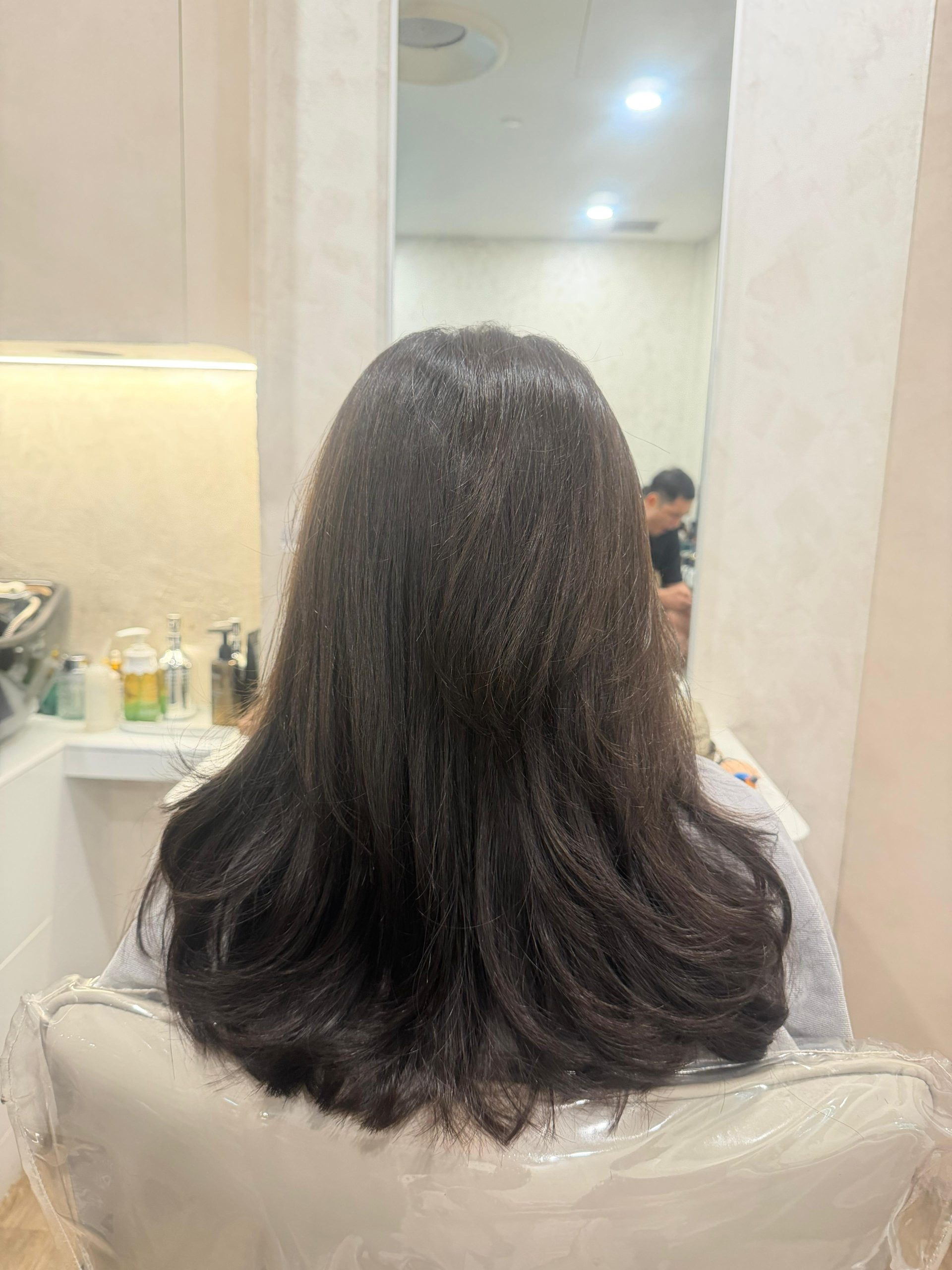 Back view of long dark hair styled with loose waves