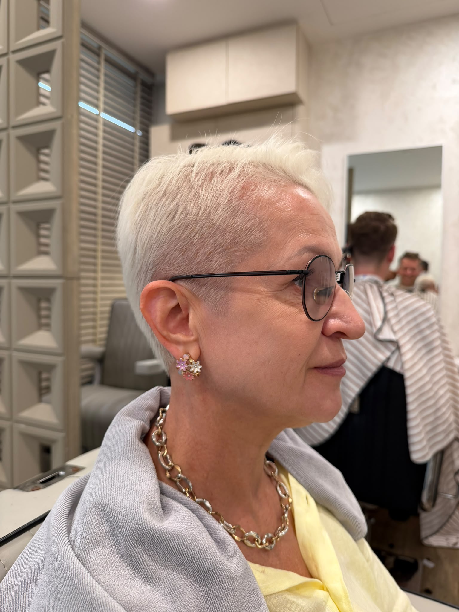 Short light-coloured haircut worn with glasses