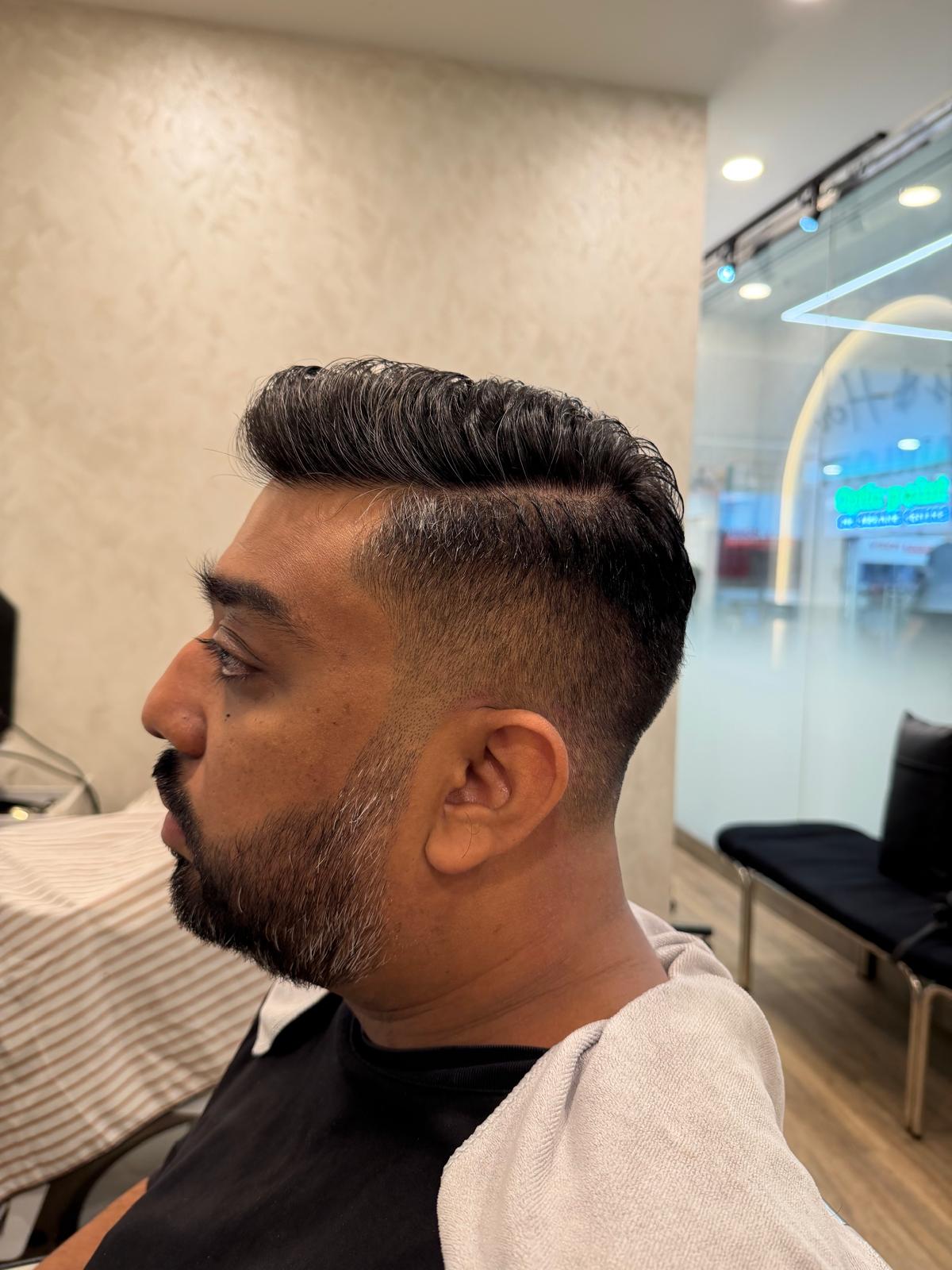 Side view of a neatly shaped beard and short haircut